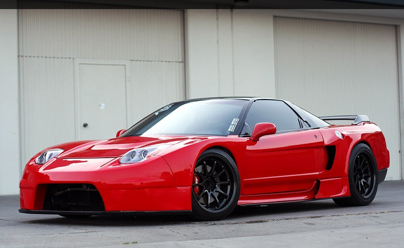 Red Acura NSX front angle view with widebody kit, aftermarket wheels, and lowered stance, modified performance car build