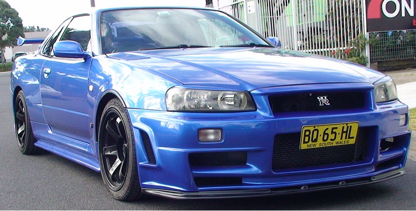 Blue Nissan Skyline R34 with JSAI Aero front bumper and body kit front angle view