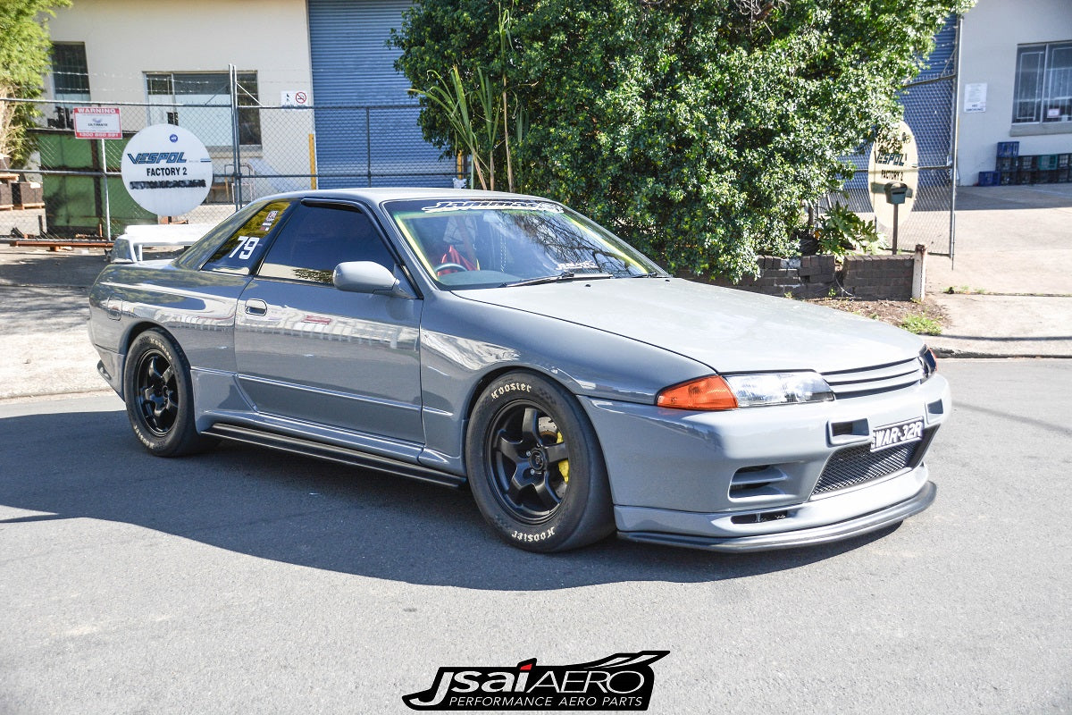 Front side view of a grey Nissan Skyline R32 with JSAI Aero side skirts, front lip, and black wheels