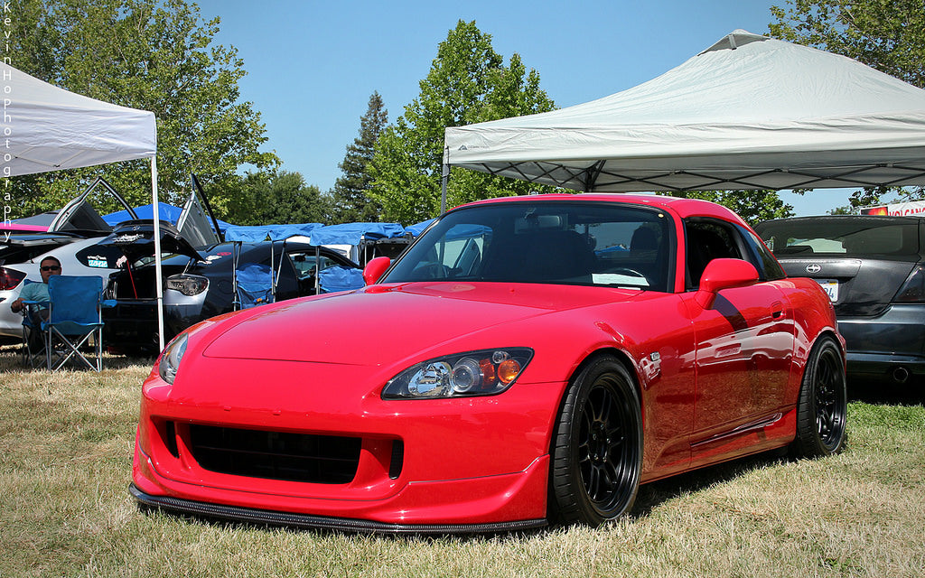 Red Honda S2000 lowered stance at car show, modified street build with aftermarket wheels and custom front lip