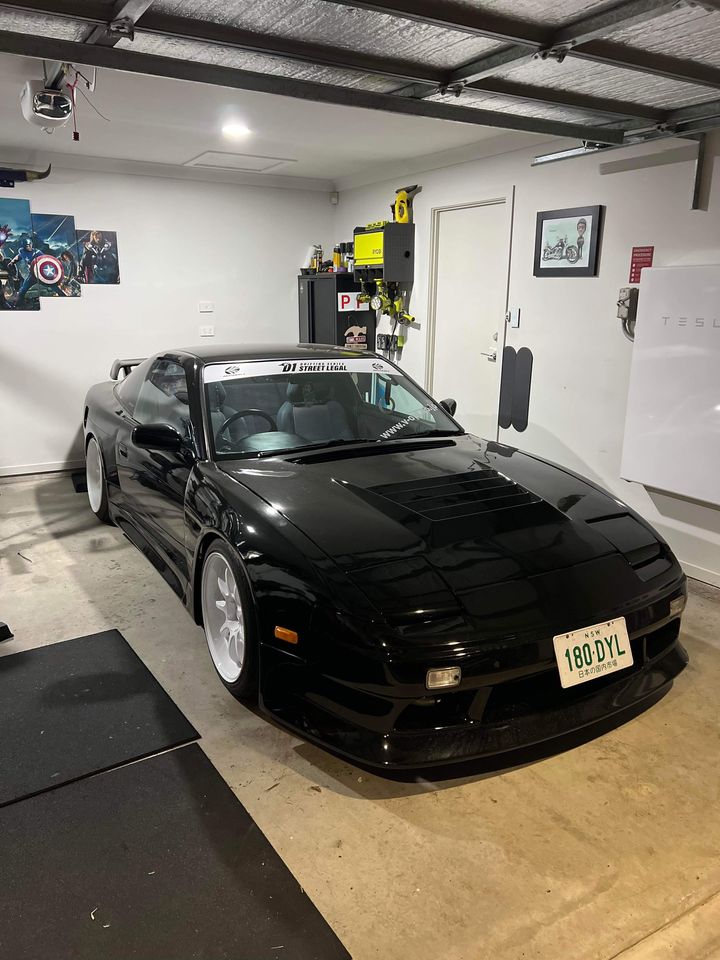 Black Nissan Silvia S13 with JSAI Aero performance body kit and aero parts installed in garage