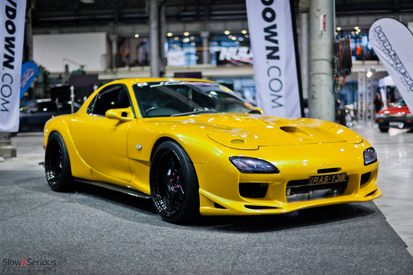 Yellow Mazda RX-7 FD3S with JSAI Aero body kit front lip and side skirts front angle view show car