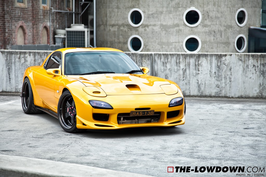 Yellow Mazda RX-7 FD3S with JSAI Aero front lip and side skirts aftermarket body kit front angle view