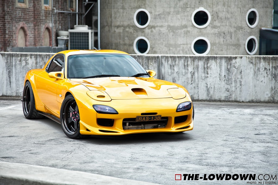 Yellow Mazda RX-7 FD3S with JSAI Aero front lip and side skirts aftermarket body kit front angle view