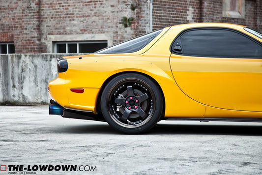 Close-up rear side view of yellow Mazda RX-7 FD3S with JSAI Aero rear lip and side skirts aftermarket body kit detail