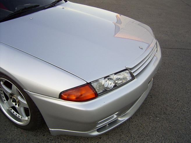 Close-up of Nissan Skyline R32 front headlight and bumper detail