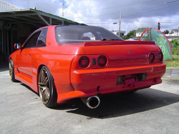 Rear three-quarter view of red Nissan Skyline R32 with aero body kit