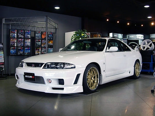 Front angle view of Nissan Skyline R33 with aero body kit displayed in showroom