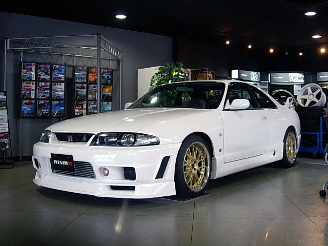 Front angle view of Nissan Skyline R33 with aero body kit displayed in showroom
