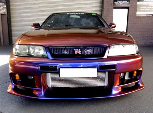 Front view of Nissan Skyline R33 GT-R with aftermarket aero front bumper and intercooler