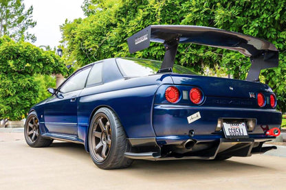 Rear angle view of blue Nissan Skyline R33 GT-R with GT wing and rear diffuser