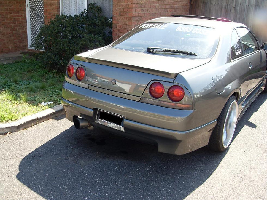 Rear angle view of Nissan Skyline R33 with aftermarket aero body kit