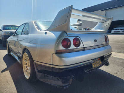 Rear angle view of Nissan Skyline R33 with GT wing and aero body kit