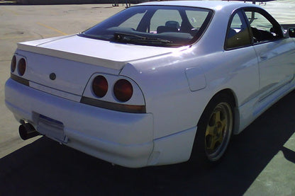 Rear view of Nissan Skyline R33 showcasing aftermarket aero body kit styling and performance build design.