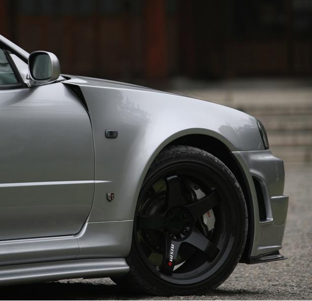 Close-up of Nissan Skyline R34 front fender, wheel, and side skirt