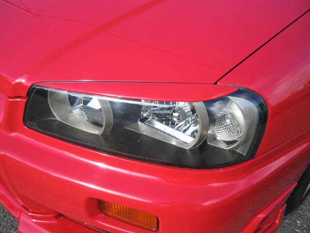Close-up of Nissan Skyline R34 headlight and front bumper detail