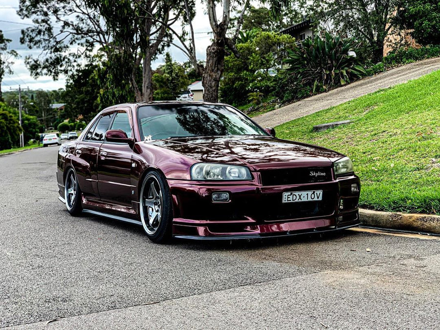 Nissan Skyline R34 fitted with JSAI Aero body kit parked on street front view