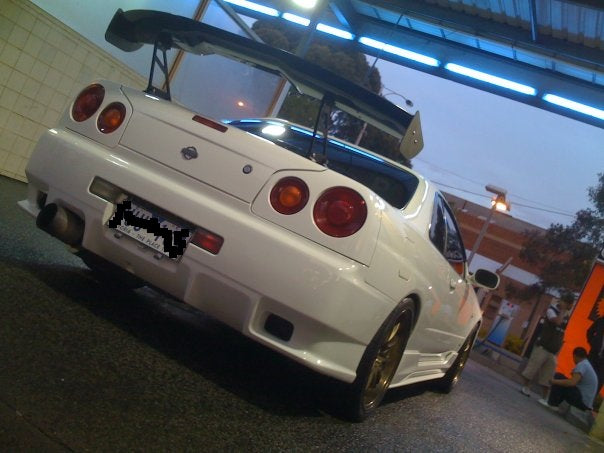 Rear view of white Nissan Skyline R34 fitted with JSAI Aero body kit and GT wing