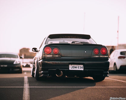 Rear view of Nissan Skyline R34 with JSAI Aero body kit parked in parking lot