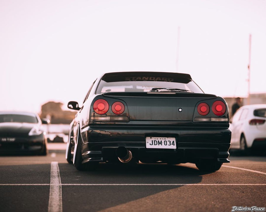 Rear view of Nissan Skyline R34 with JSAI Aero body kit parked in parking lot