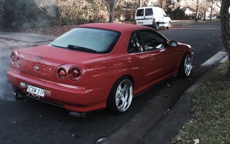 Red Nissan Skyline R34 with JSAI Aero side skirts and performance aero body kit