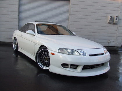 White Toyota Soarer with custom full body kit, front bar, and side skirts installed, modified performance car exterior upgrade
