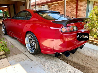 Red Toyota Supra rear side view with aftermarket wheels, custom body kit, rear diffuser, and performance exhaust system upgrade