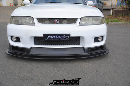 Front view of a white Nissan Skyline R33 with JSAI Aero front lip, mesh grille, and integrated fog lights