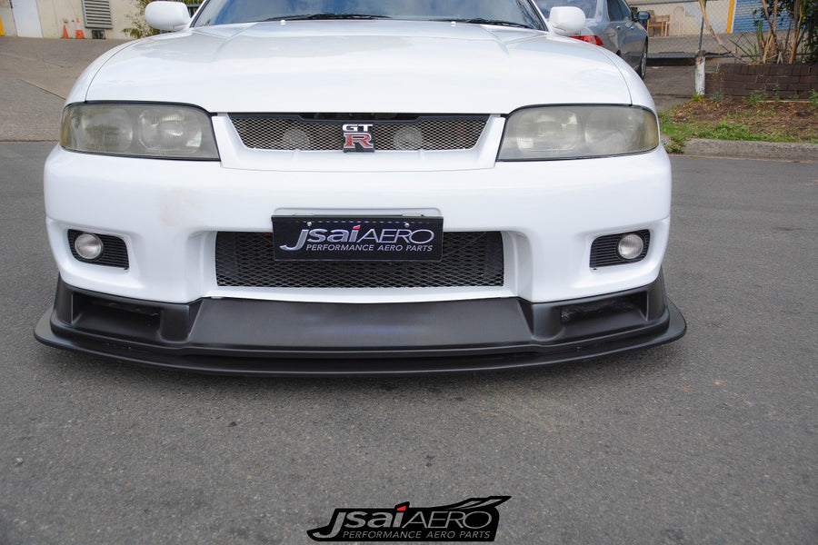 Front view of a white Nissan Skyline R33 with JSAI Aero front lip, mesh grille, and integrated fog lights