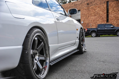 Close-up of JSAI Aero side skirt installed on a white Nissan Skyline R33 with aftermarket wheels